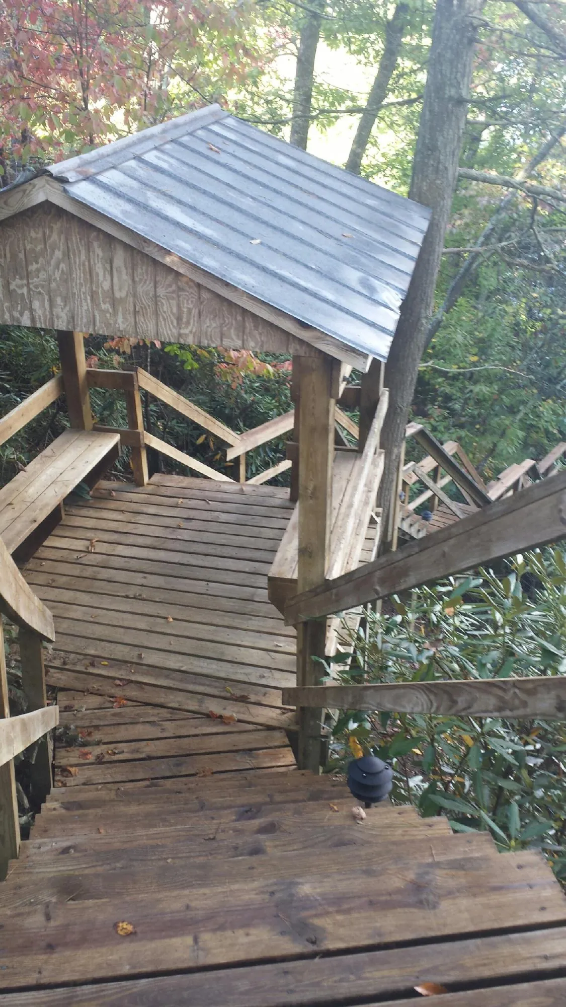 Metal roofed shelter over wooden steps on a wooded walkway — Skylight Repair & Installation work by our crew in Center Hill