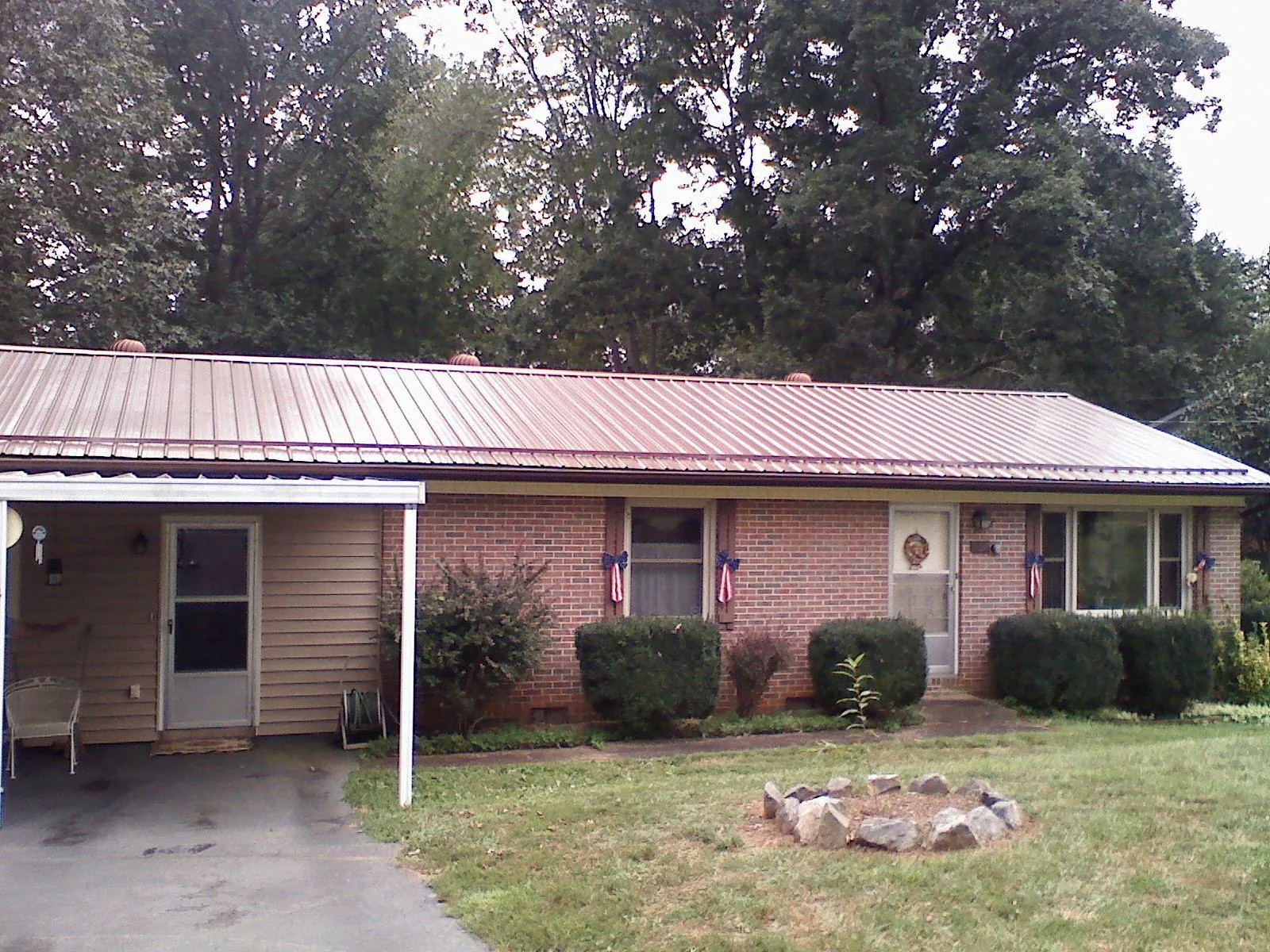 Bronze metal roof and carport on a brick ranch home — Roof Repair work by our crew in Center Hill